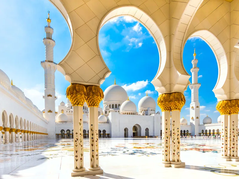 Cour intérieure d'une mosquée aux arcades blanches et dorées
